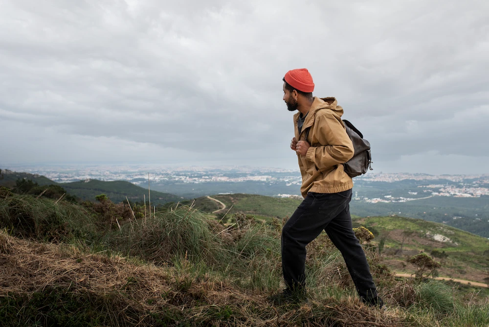 Hiker holding lower back in pain during trail walk due to strain and overuse